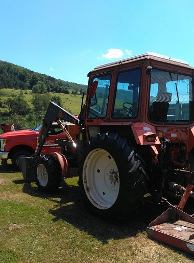 On-site farm tire installation on red farm tractor